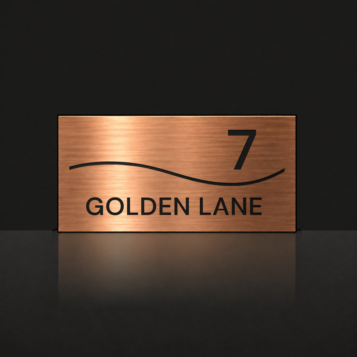 Brushed copper house number and street name sign with a brushed metal look, The Bokarina, reading 7 Golden Lane in black lettering, with a wave line.