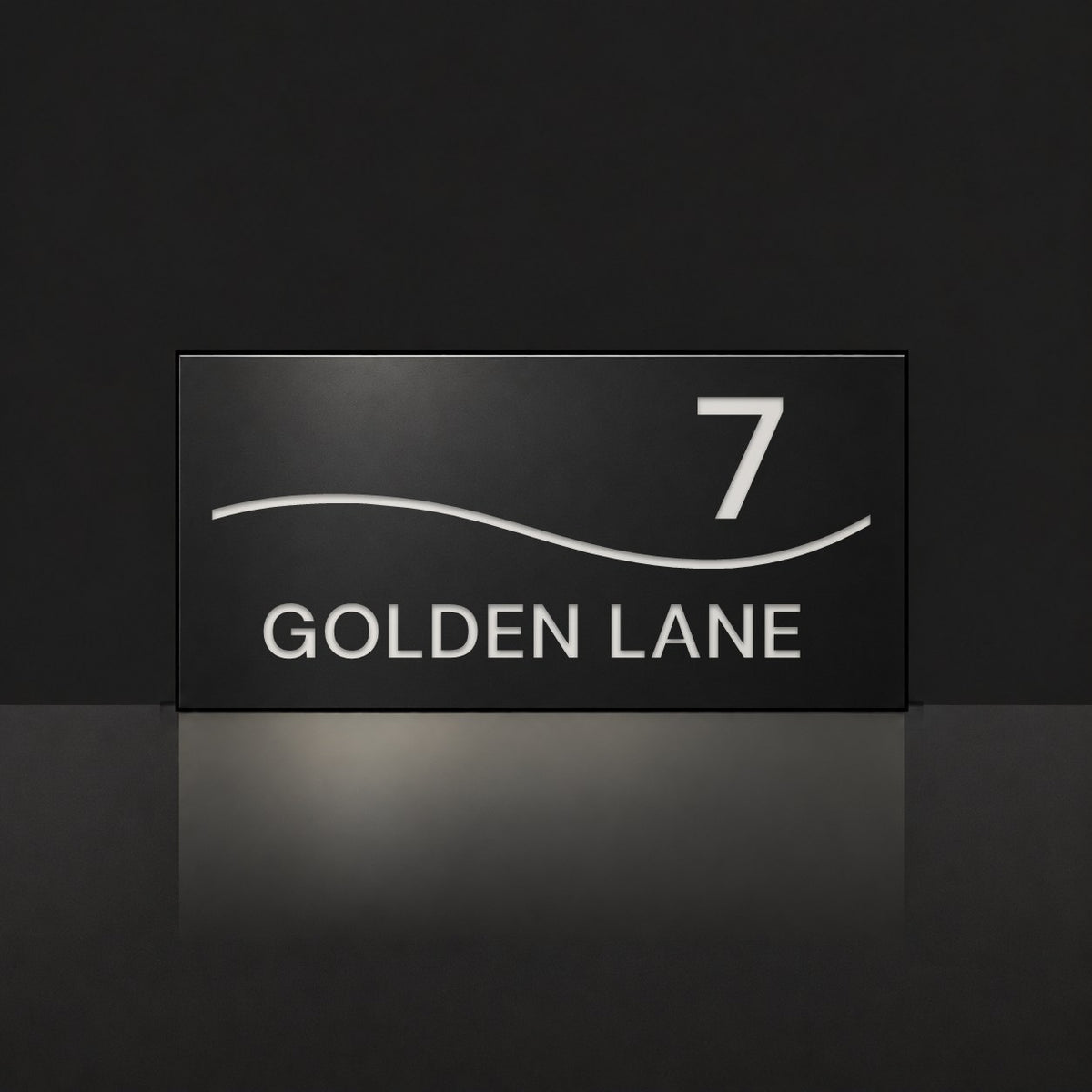 Matte black house number and street name sign, The Bokarina, reading 7 Golden Lane in white lettering, with a wave line.