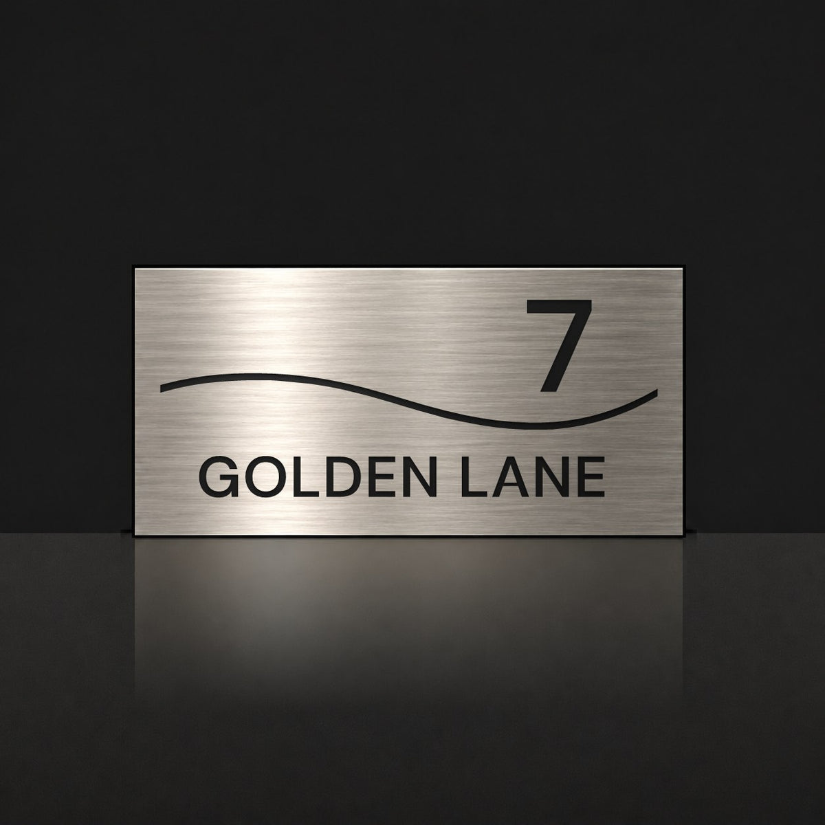 Brushed silver house number and street name sign with a brushed metal look, The Bokarina, reading 7 Golden Lane in black lettering, with a wave line.