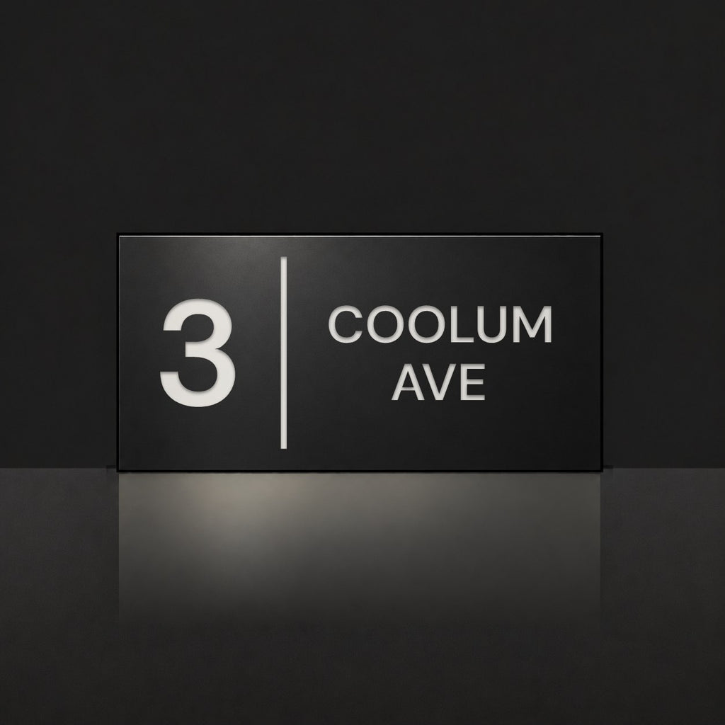 Matte black house number and street name sign, The Coolum, reading 3 Coolum Ave in white lettering, with a dividing line.