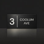 Matte black house number and street name sign, The Coolum, reading 3 Coolum Ave in white lettering, with a dividing line.