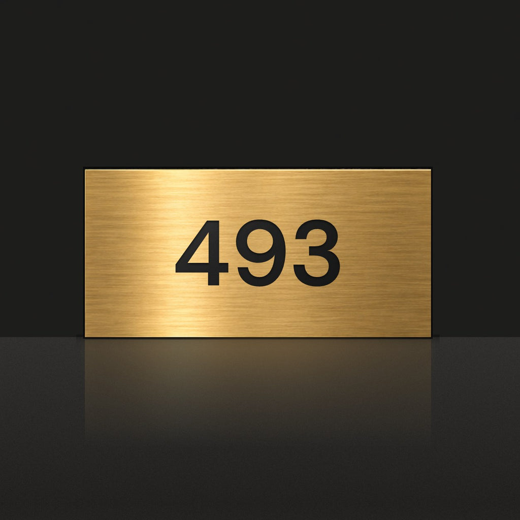 Brushed gold house number sign with a brushed metal look, The Kawana, with the number 493 in black lettering.