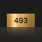Brushed gold house number sign with a brushed metal look, The Kawana, with the number 493 in black lettering.