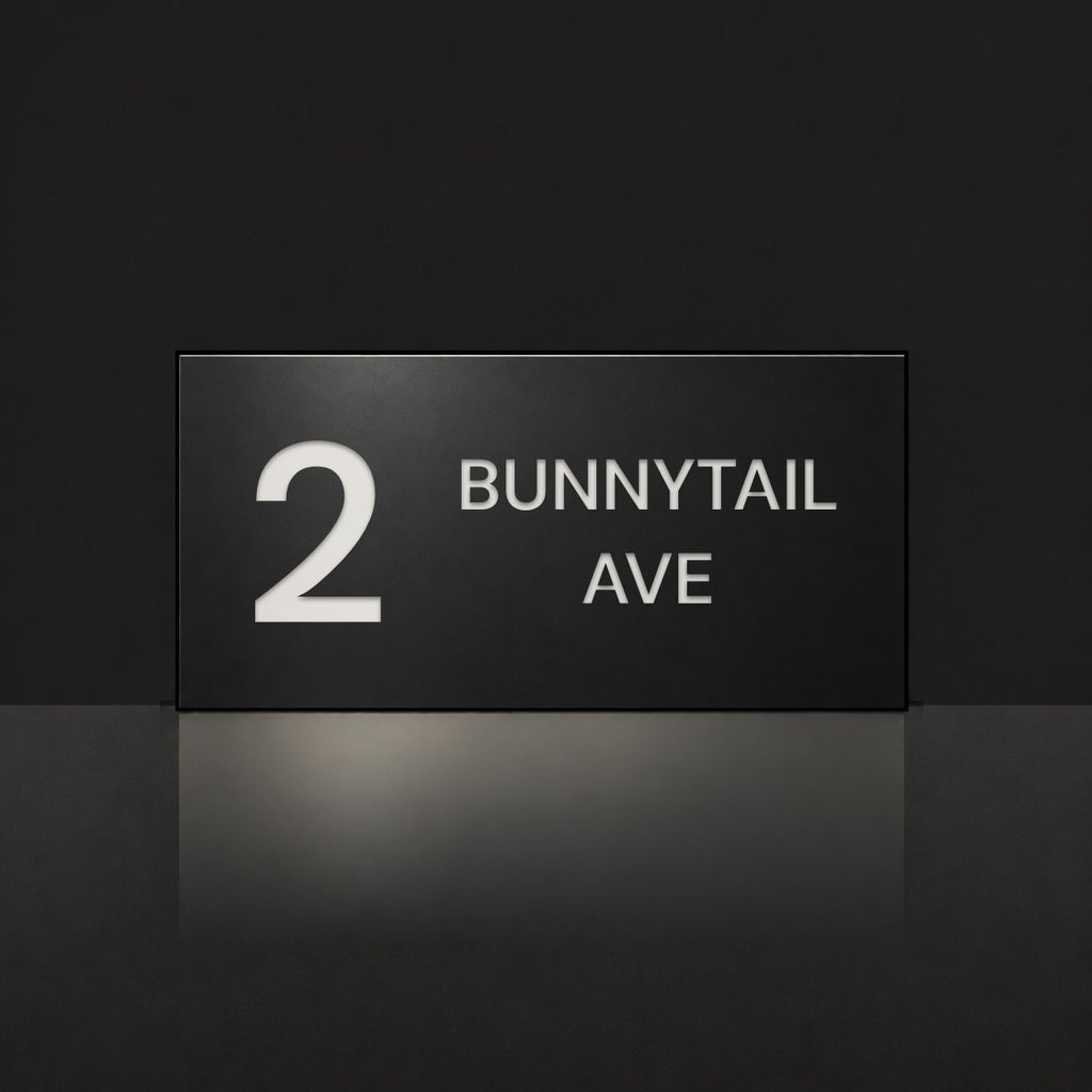 Matte black house number and street name sign, The Maleny, reading 2 Bunnytail Ave in white lettering.