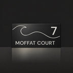 Matte black house number and street name sign, The Moffat, reading 7 Moffat Court in white lettering, with a wave.