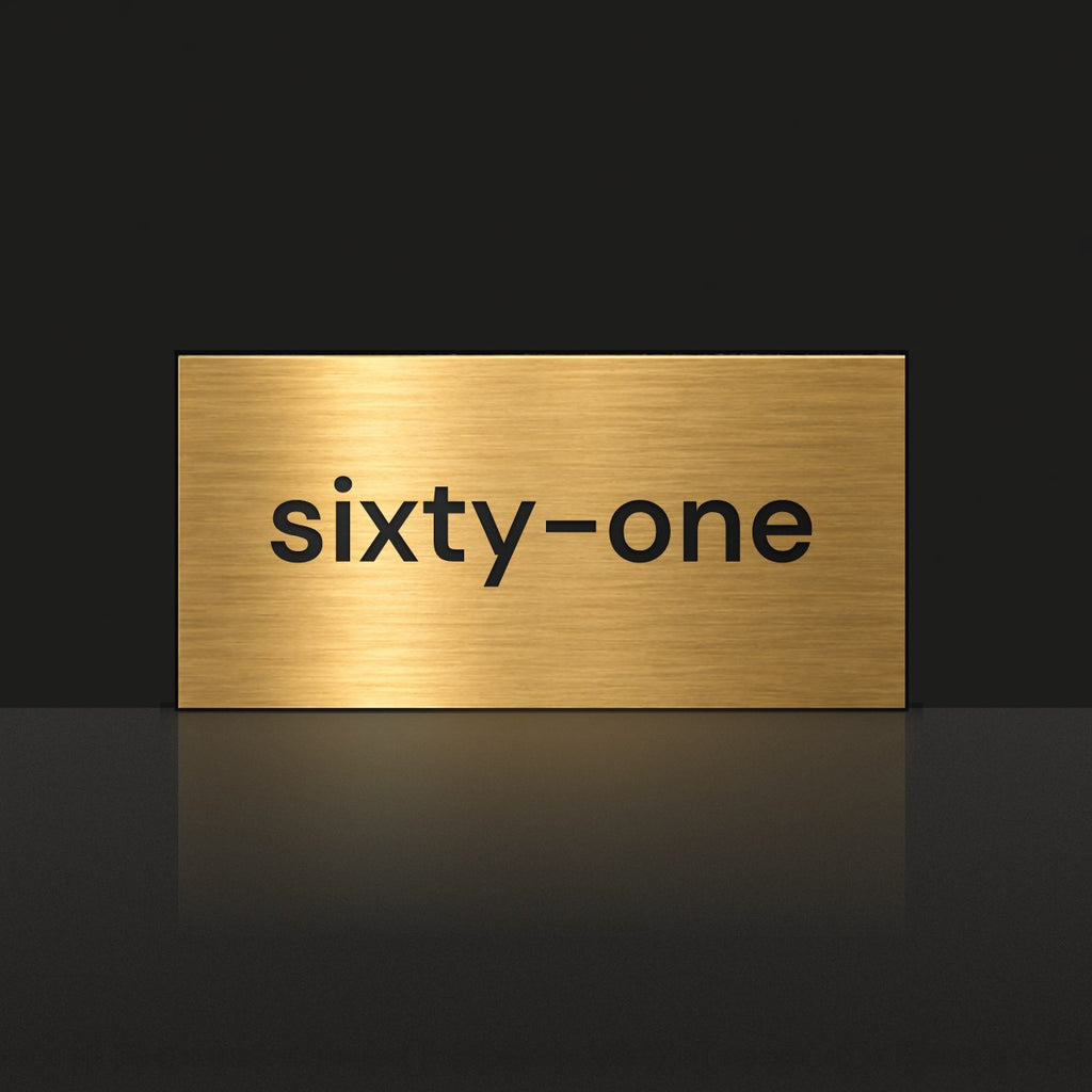 Brushed gold house number sign with a brushed metal look, The Montville, with the number spelled out as sixty-one in black lettering.