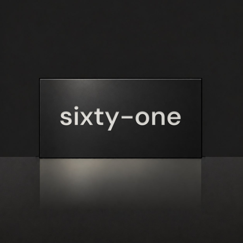 Matte black house number sign, The Montville, with the number spelled out as sixty-one in white lettering.