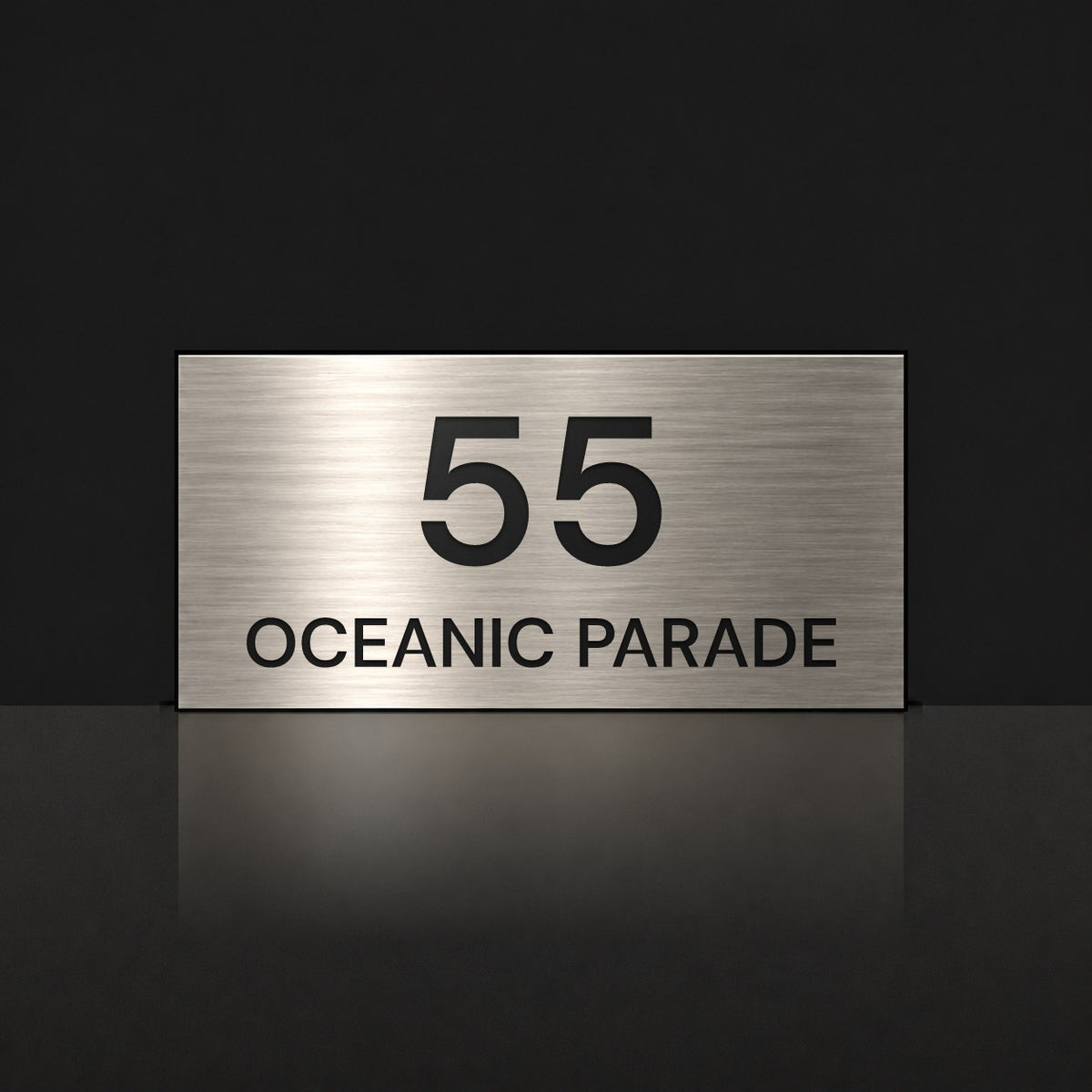 Brushed silver house number and street name sign with a brushed metal look, The Peregian, reading 55 Oceanic Parade in black lettering.
