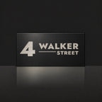 Brushed silver house number and street name sign with a brushed metal look, The Alexandra, black face reading 4 Walker Street in silver lettering.