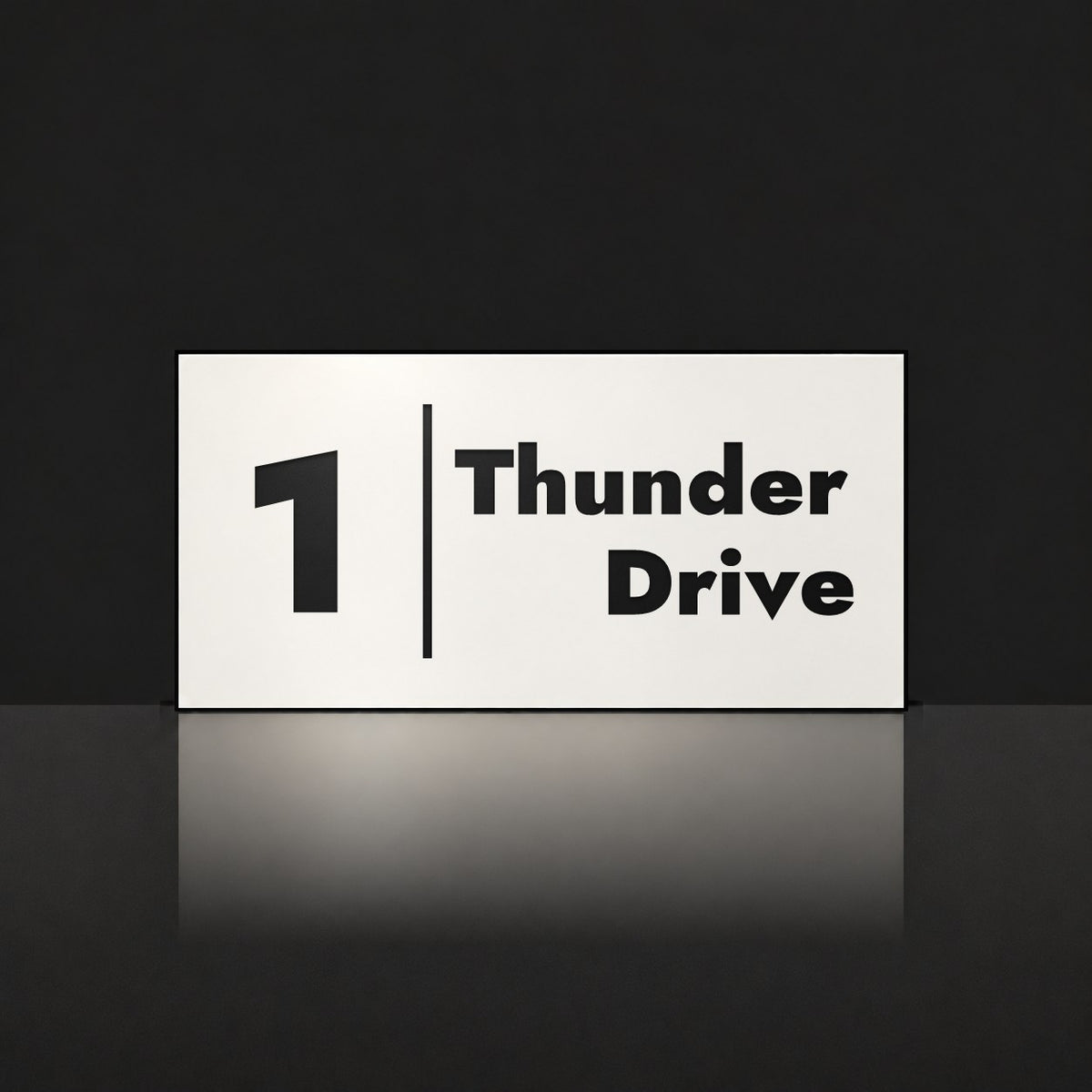 Matte white house number and street name sign, The Coolum, reading 1 Thunder Drive in black lettering, with a dividing line.