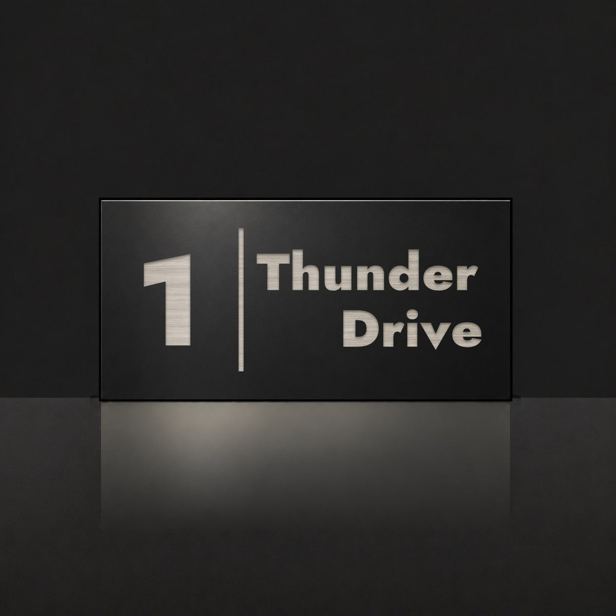 Brushed silver house number and street name sign with a brushed metal look, The Coolum, black face reading 1 Thunder Drive in silver lettering, with a dividing line.
