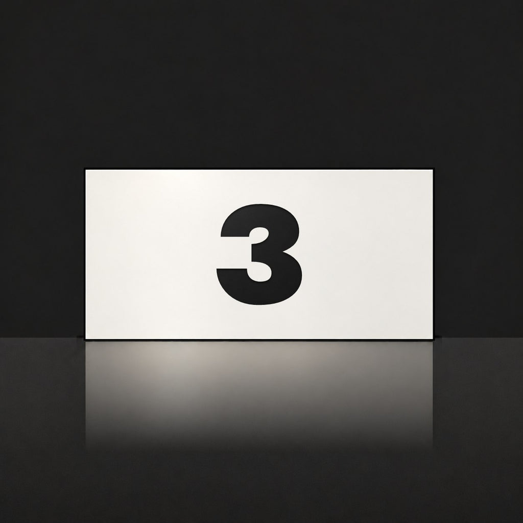 Matte white house number sign, The Kawana, with the number 3 in black lettering.