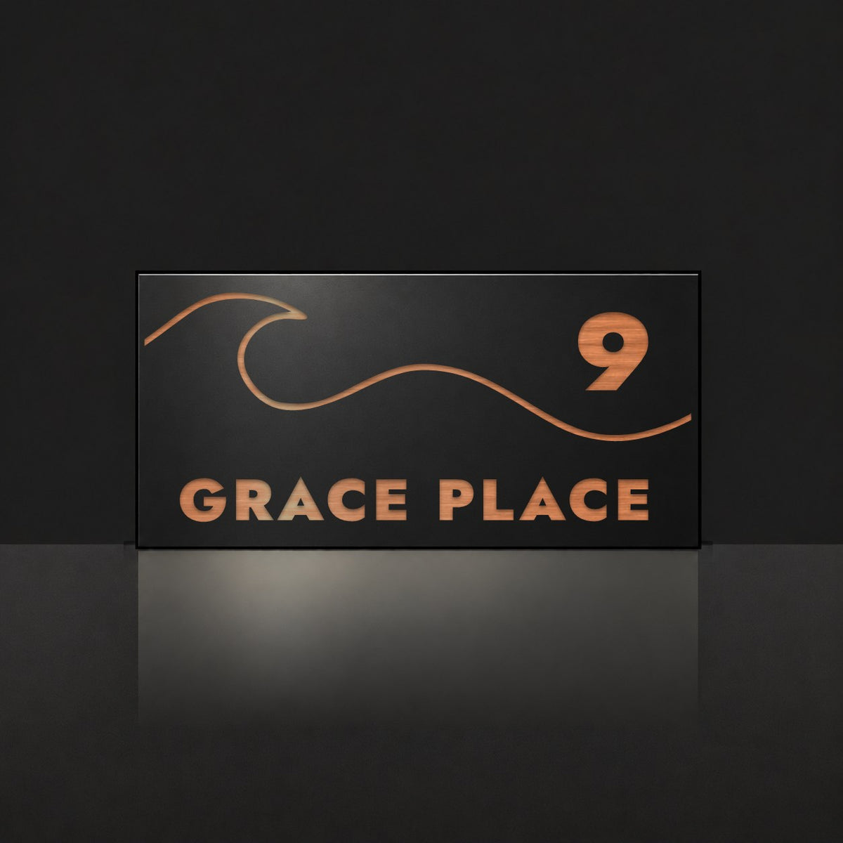 Brushed copper house number and street name sign with a brushed metal look, The Moffat, black face reading 9 Grace Place in copper lettering, with a wave.