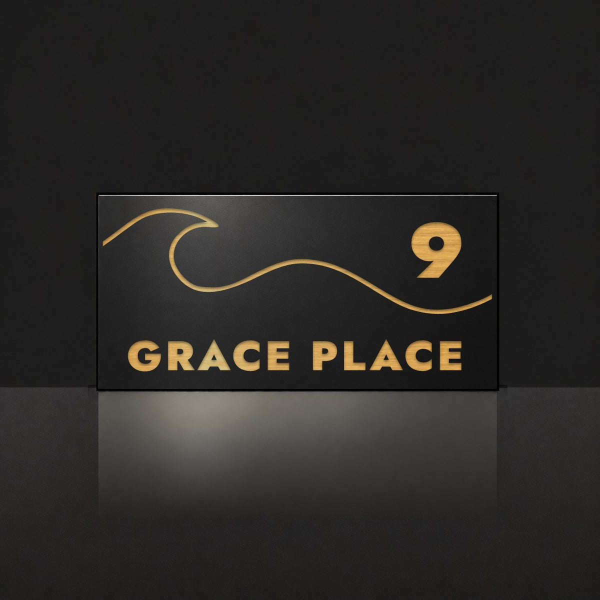 Brushed gold house number and street name sign with a brushed metal look, The Moffat, black face reading 9 Grace Place in gold lettering, with a wave.