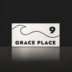 Matte white house number and street name sign, The Moffat, reading 9 Grace Place in black lettering, with a wave.