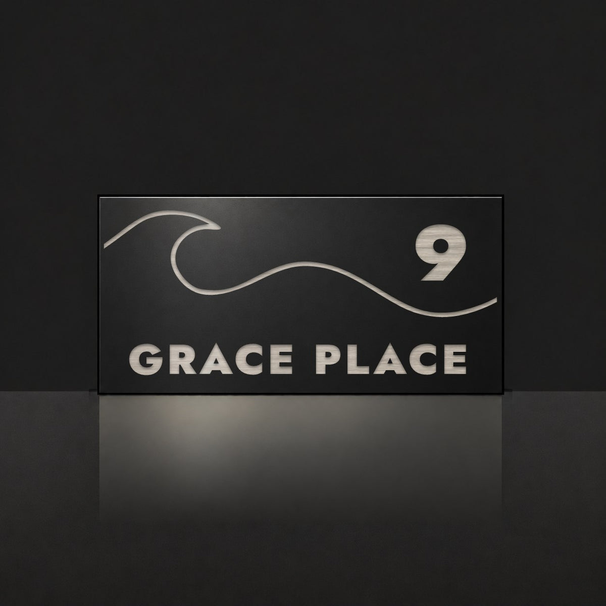 Brushed silver house number and street name sign with a brushed metal look, The Moffat, black face reading 9 Grace Place in silver lettering, with a wave.