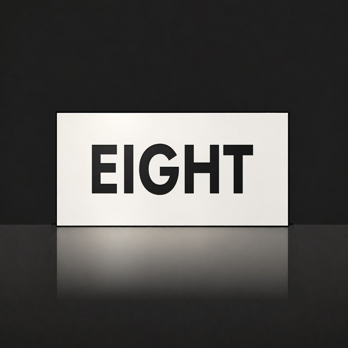 Matte white house number sign, The Montville, with the number spelled out as eight in black lettering.