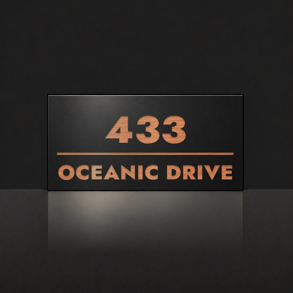 Brushed copper house number and street name sign with a brushed metal look, The Noosa, black face reading 433 Oceanic Drive in copper lettering.