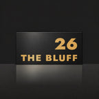 Brushed gold house number and street name sign with a brushed metal look, The Peregian, black face reading 26 The Bluff in gold lettering.