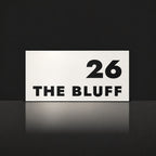 Matte white house number and street name sign, The Peregian, reading 26 The Bluff in black lettering.