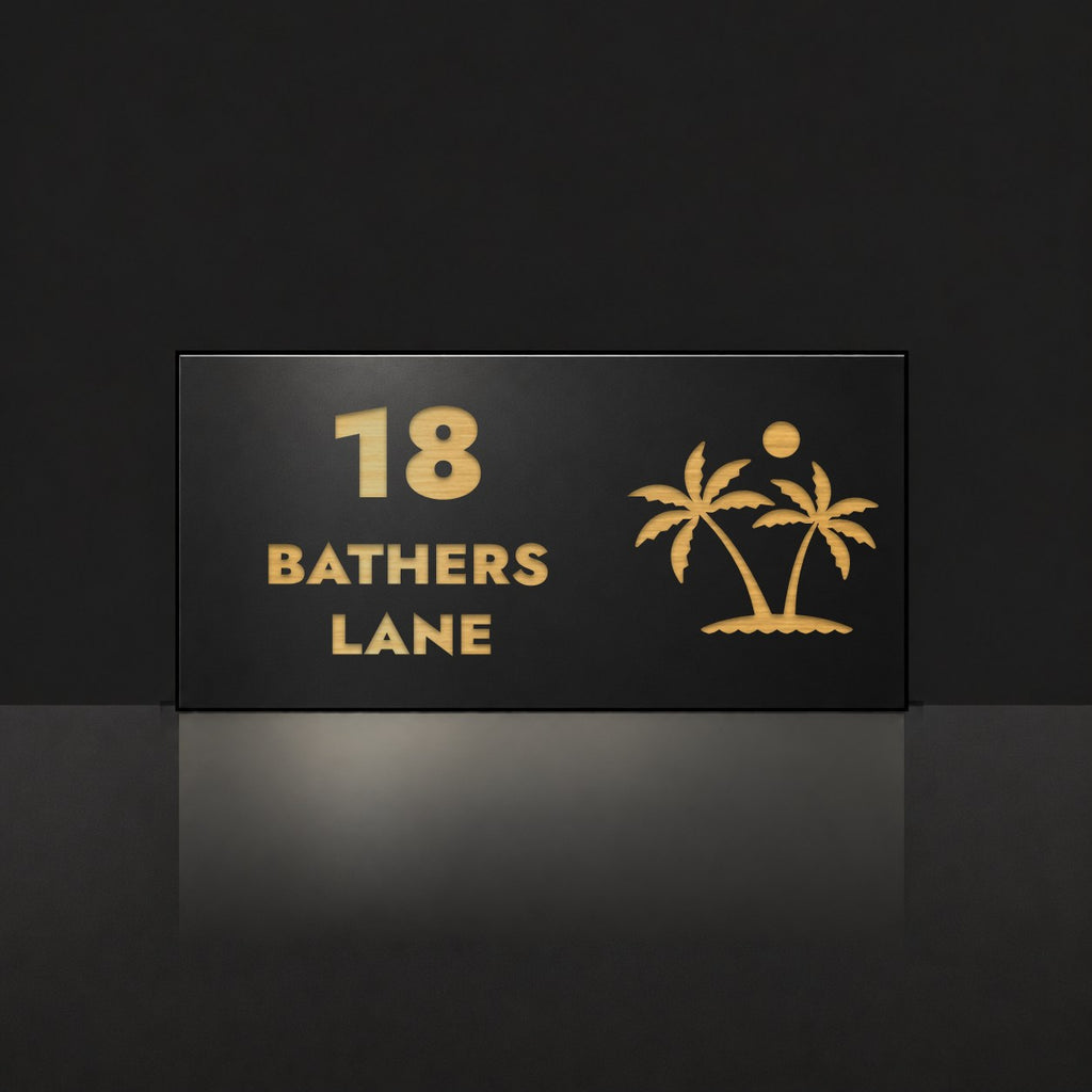 Brushed gold house number and street name sign with a brushed metal look, The Yaroomba, black face reading 18 Bathers Lane in gold lettering, with palm trees and a sun.