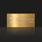 Brushed gold house number and street name sign with a brushed metal look, The Alexandra, reading 7 Hamilton Dr in white lettering.