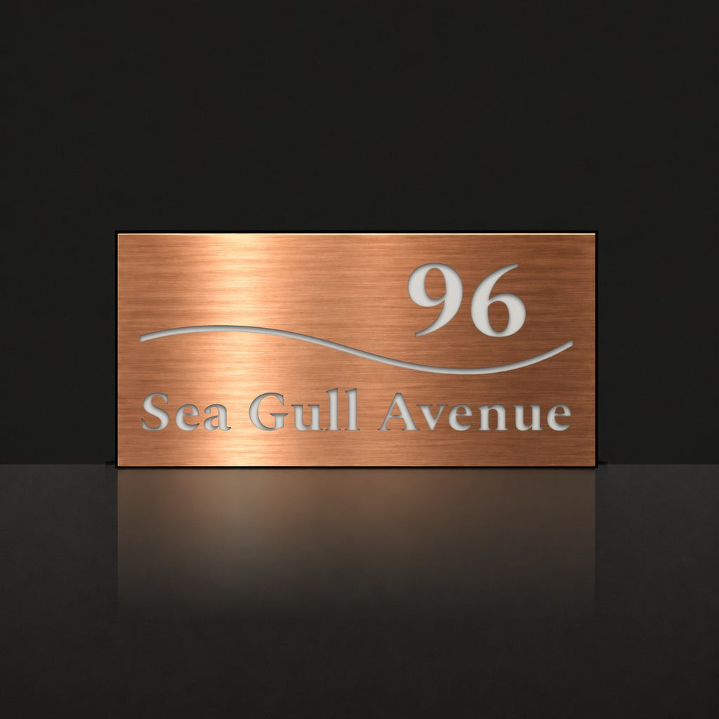 Brushed copper house number and street name sign with a brushed metal look, The Bokarina, reading 96 Sea Gull Avenue in white lettering, with a wave line.