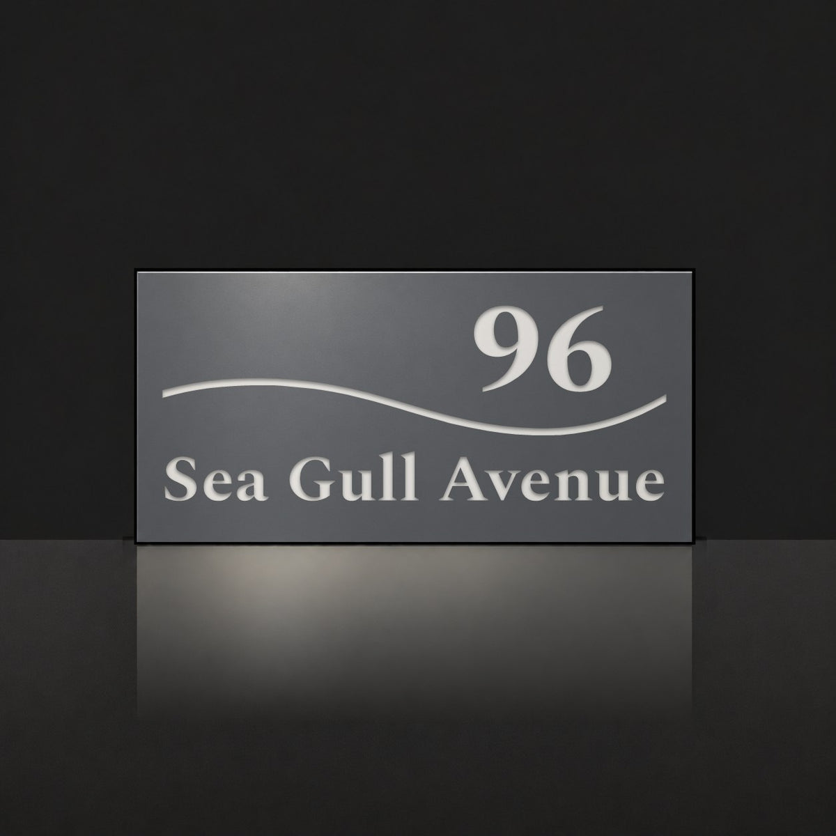 Matte charcoal house number and street name sign, The Bokarina, reading 96 Sea Gull Avenue in white lettering, with a wave line.