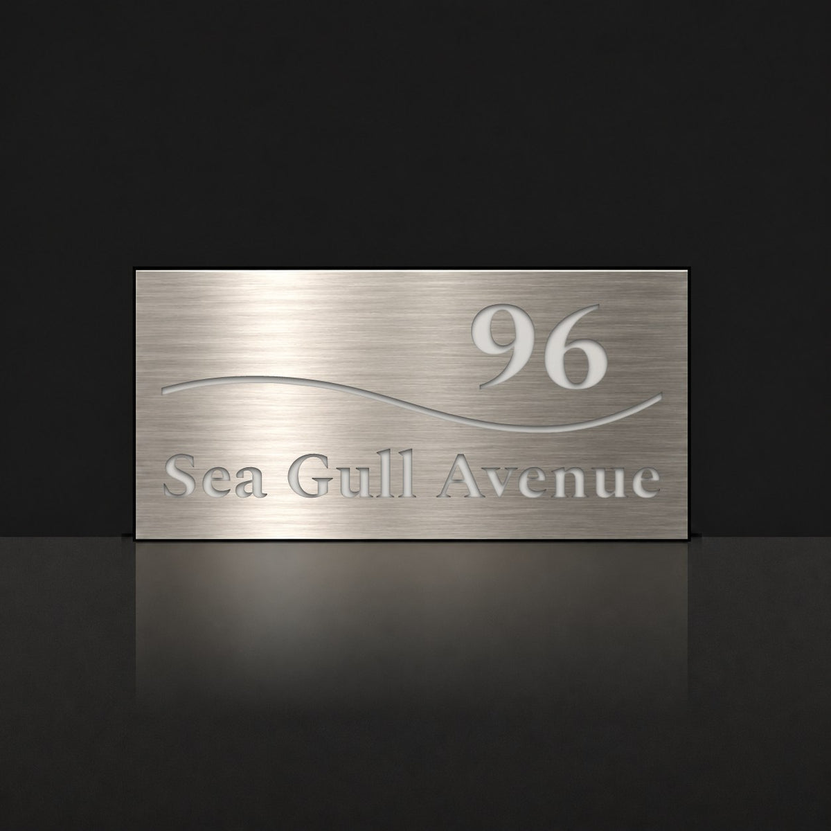 Brushed silver house number and street name sign with a brushed metal look, The Bokarina, reading 96 Sea Gull Avenue in white lettering, with a wave line.