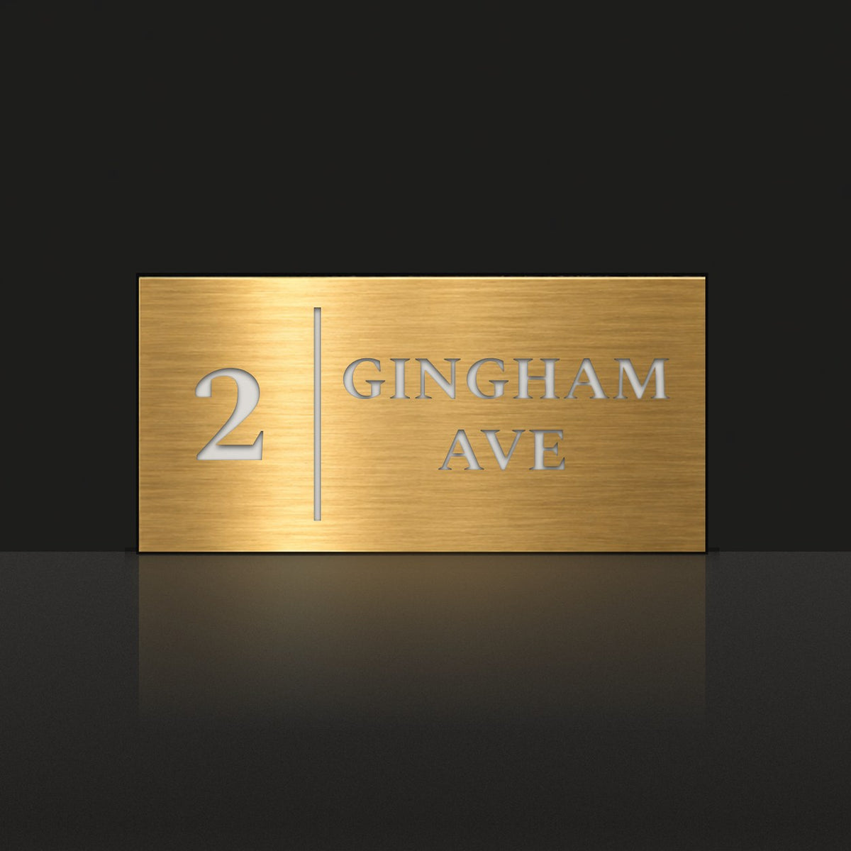 Brushed gold house number and street name sign with a brushed metal look, The Coolum, reading 2 Gingham Ave in white lettering, with a dividing line.