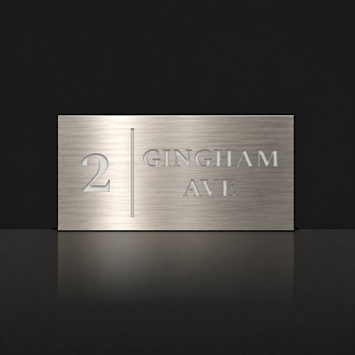 Brushed silver house number and street name sign with a brushed metal look, The Coolum, reading 2 Gingham Ave in white lettering, with a dividing line.