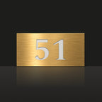 Brushed gold house number sign with a brushed metal look, The Kawana, with the number 51 in white lettering.