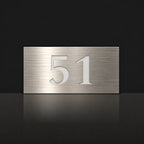 Brushed silver house number sign with a brushed metal look, The Kawana, with the number 51 in white lettering.