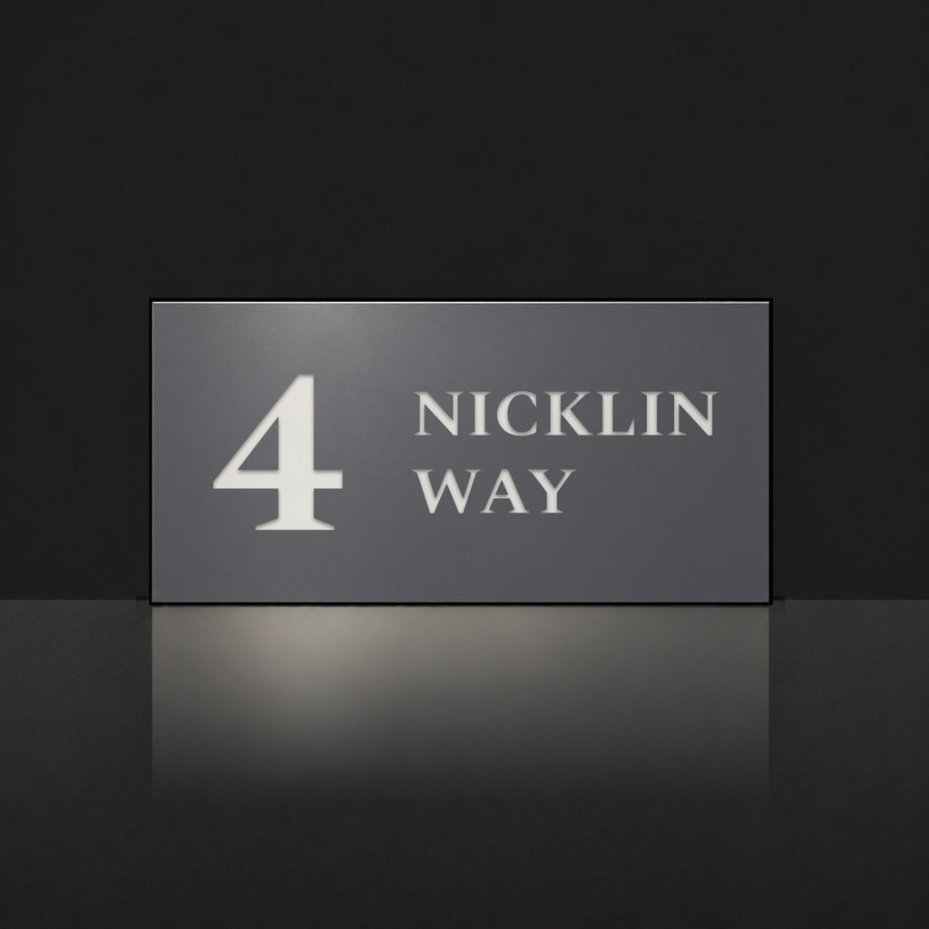Matte charcoal house number and street name sign, The Marcoola, reading 4 Nicklin Way in white lettering.