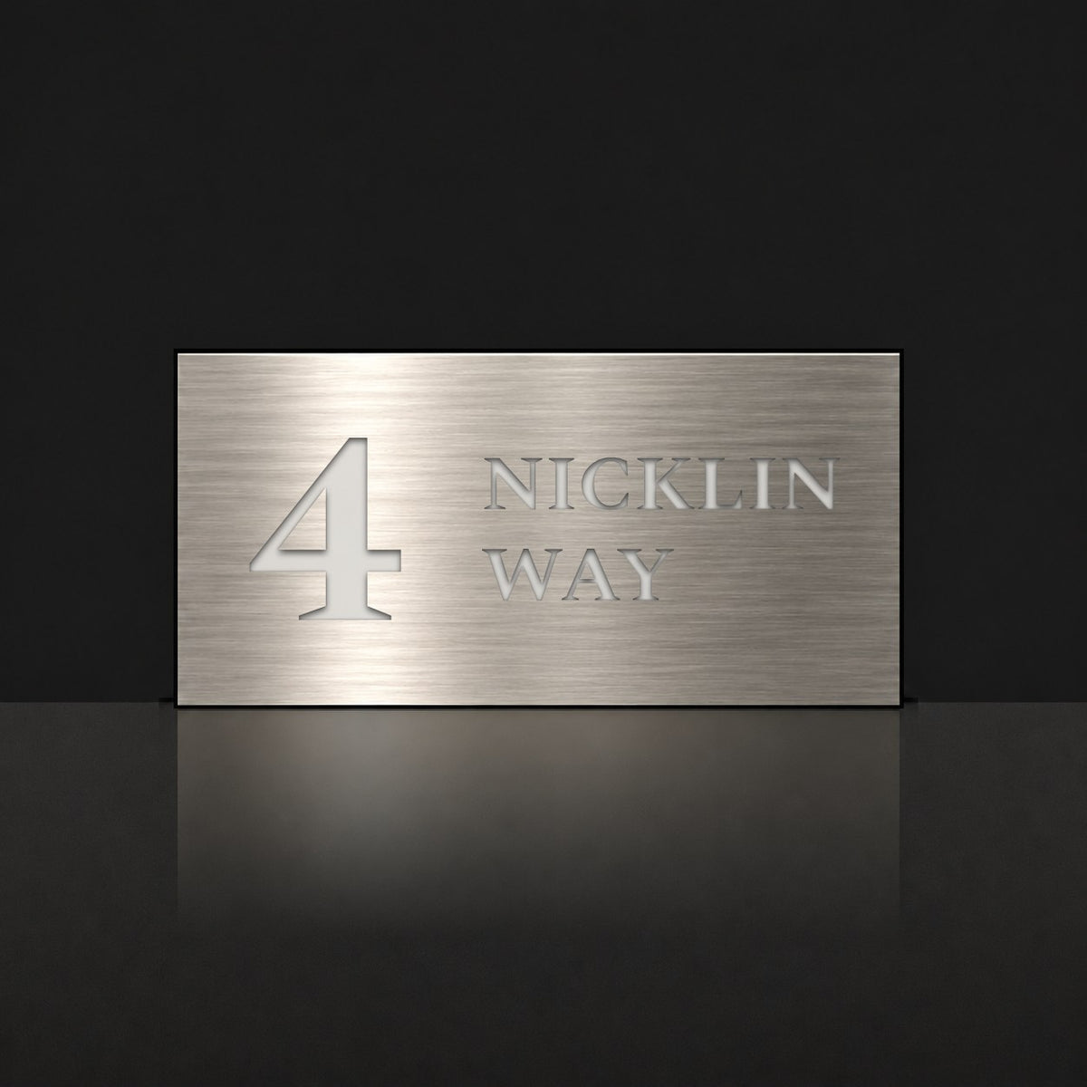 Brushed silver house number and street name sign with a brushed metal look, The Marcoola, reading 4 Nicklin Way in white lettering.