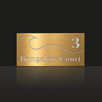 Brushed gold house number and street name sign with a brushed metal look, The Moffat, reading 3 Bungalow Court in white lettering, with a wave.