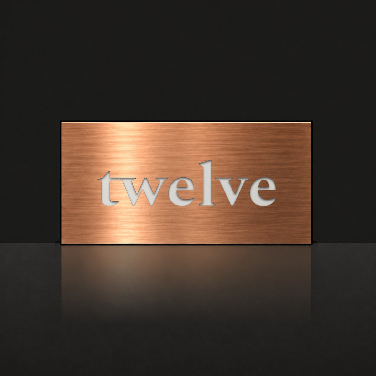 Brushed copper house number sign with a brushed metal look, The Montville, with the number spelled out as twelve in white lettering.