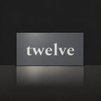 Matte charcoal house number sign, The Montville, with the number spelled out as twelve in white lettering.