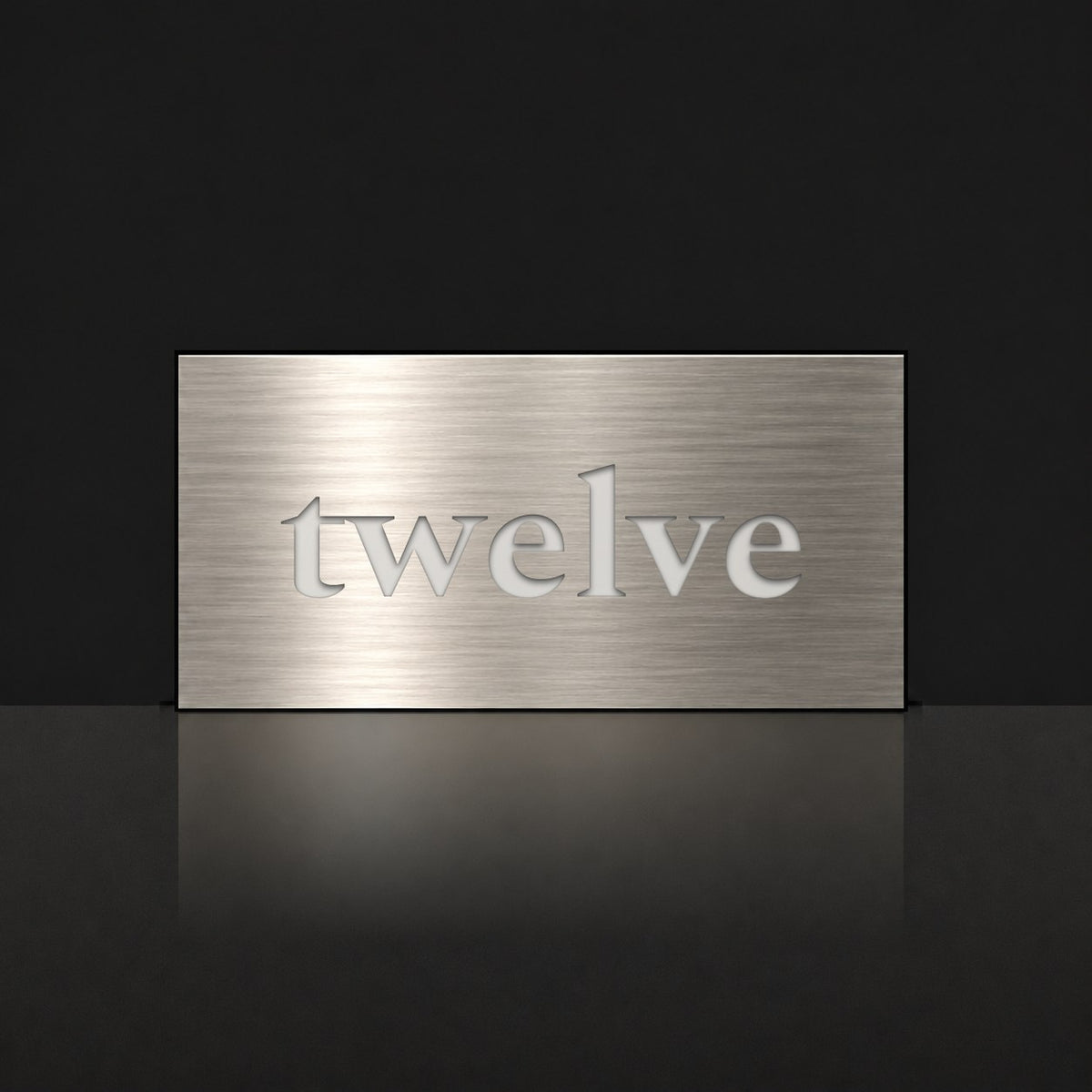 Brushed silver house number sign with a brushed metal look, The Montville, with the number spelled out as twelve in white lettering.