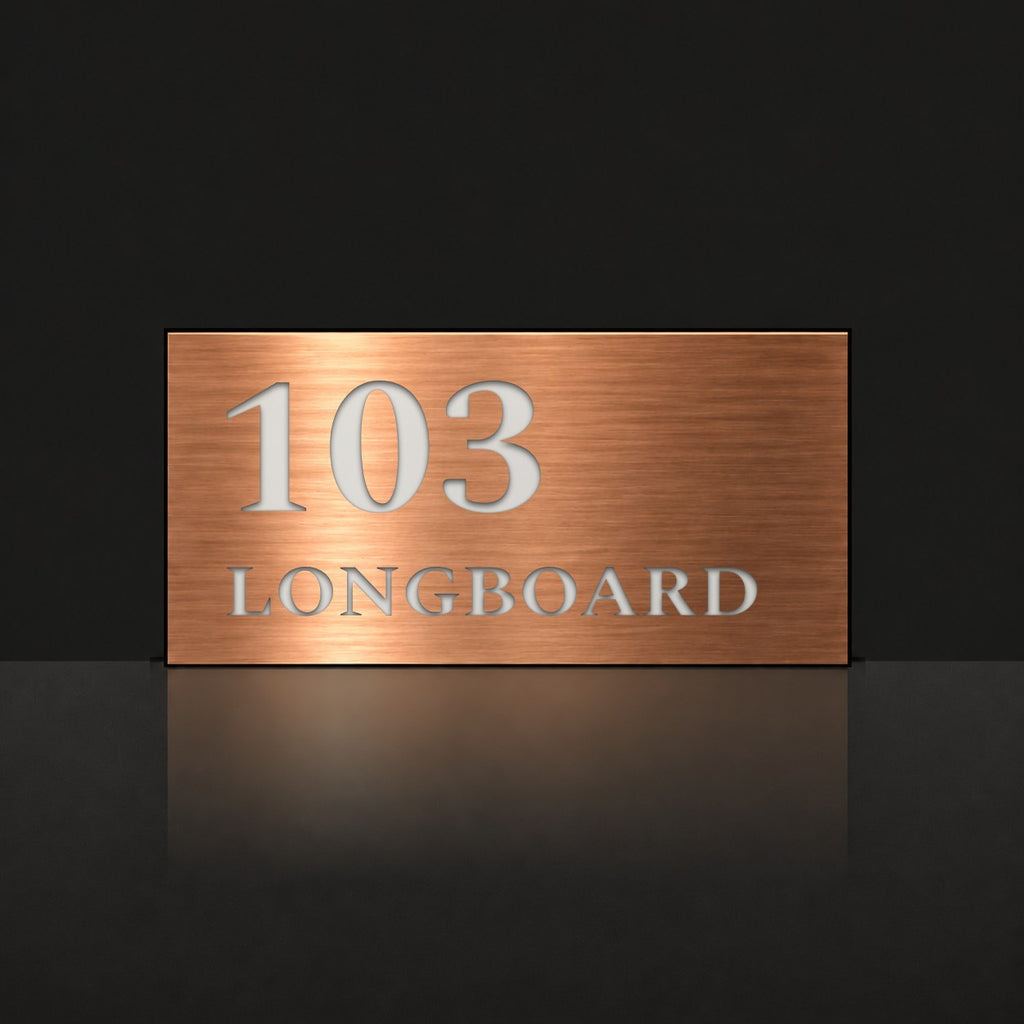 Brushed copper house number and street name sign with a brushed metal look, The Peregian, reading 103 Longboard in white lettering.
