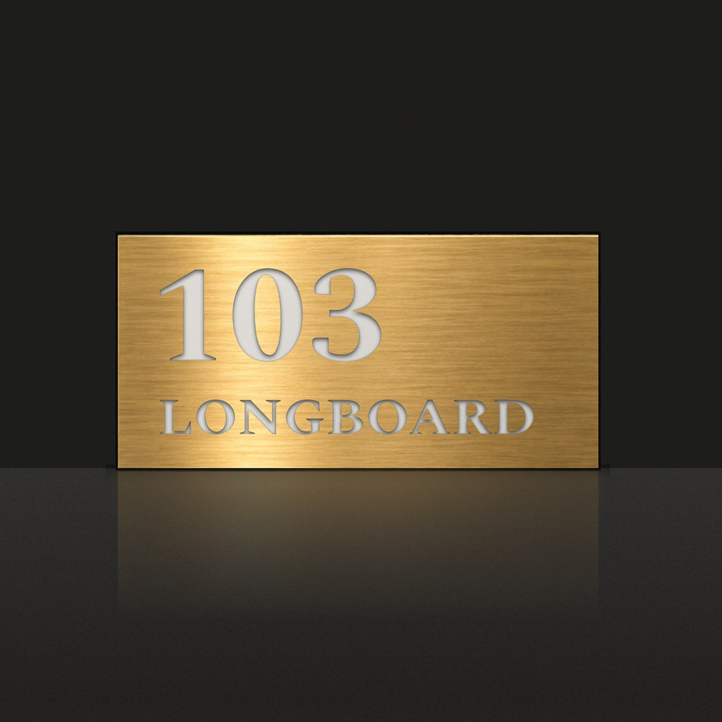 Brushed gold house number and street name sign with a brushed metal look, The Peregian, reading 103 Longboard in white lettering.