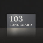 Matte charcoal house number and street name sign, The Peregian, reading 103 Longboard in white lettering.