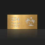Brushed gold house number and street name sign with a brushed metal look, The Yaroomba, reading 234 Palm Cove in white lettering, with palm trees and a sun.
