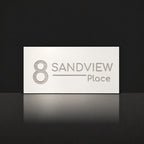 Brushed silver house number and street name sign with a brushed metal look, The Alexandra, white face reading 8 Sandview Place in silver lettering.
