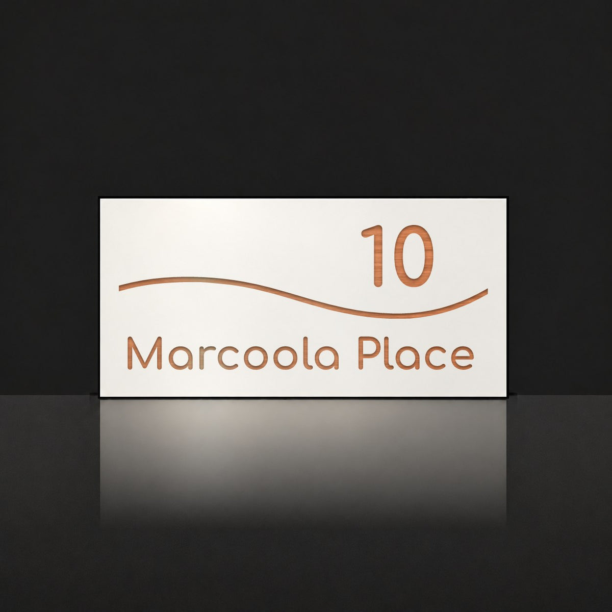 Brushed copper house number and street name sign with a brushed metal look, The Bokarina, white face reading 10 Marcoola Place in copper lettering, with a wave line.