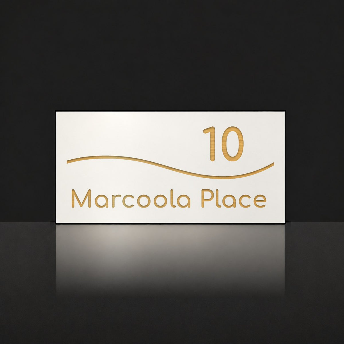 Brushed gold house number and street name sign with a brushed metal look, The Bokarina, white face reading 10 Marcoola Place in gold lettering, with a wave line.