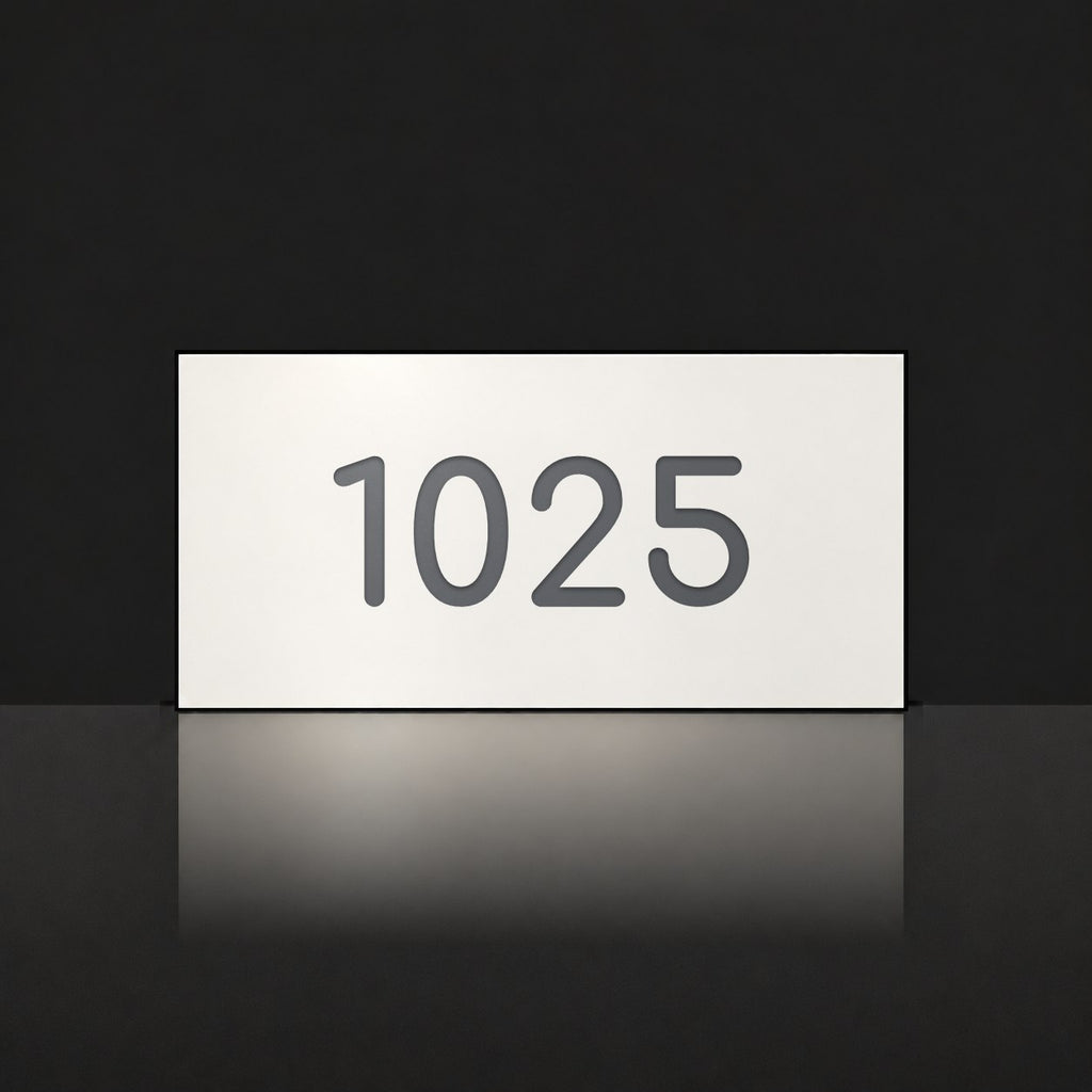 Matte white house number sign, The Kawana, with the number 1025 in charcoal lettering.