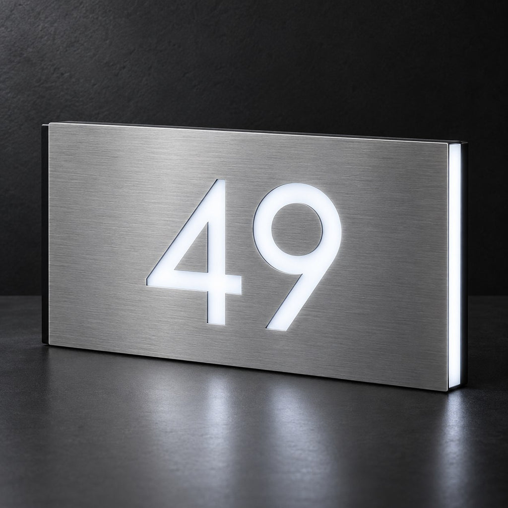 Brushed silver illuminated house number sign with a brushed metal look, The Kawana, showing the number 49 in bright white LED cutouts on a dark background.