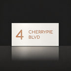 Brushed copper house number and street name sign with a brushed metal look, The Maleny, white face reading 4 Cherrypie Blvd in copper lettering.