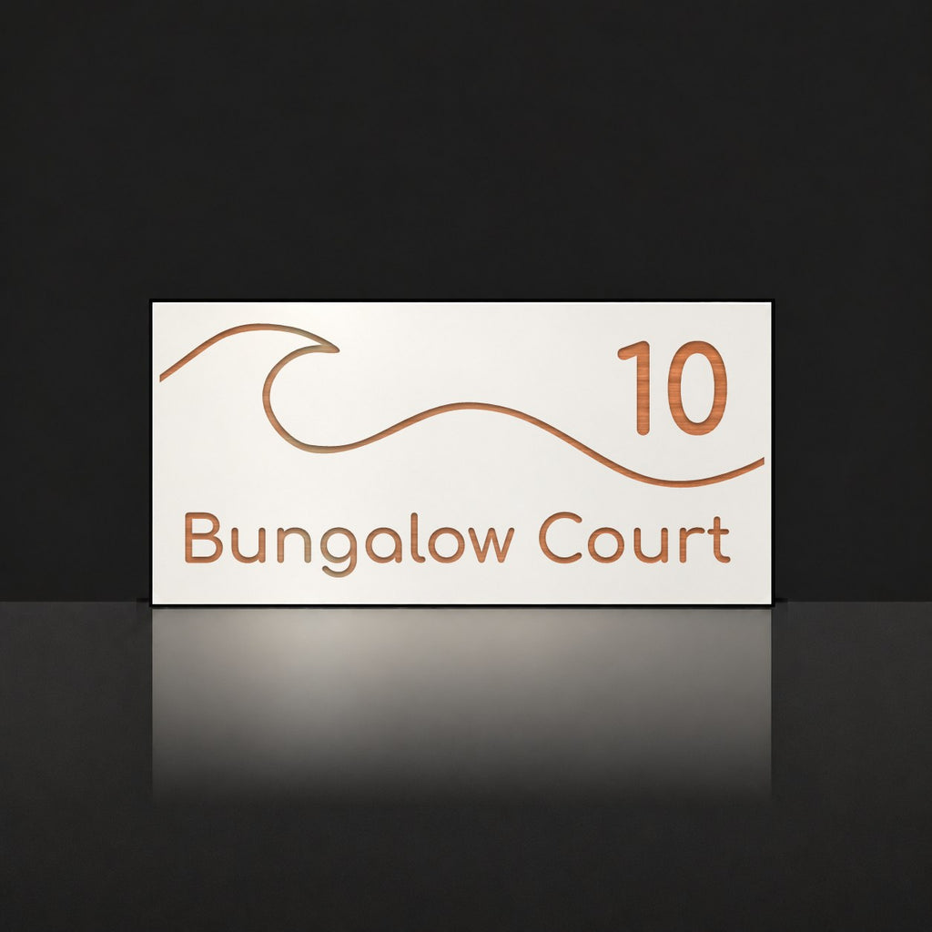 Brushed copper house number and street name sign with a brushed metal look, The Moffat, white face reading 10 Bungalow Court in copper lettering, with a wave.